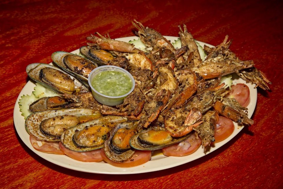 Printed seafood menu with tacos and empanadas.